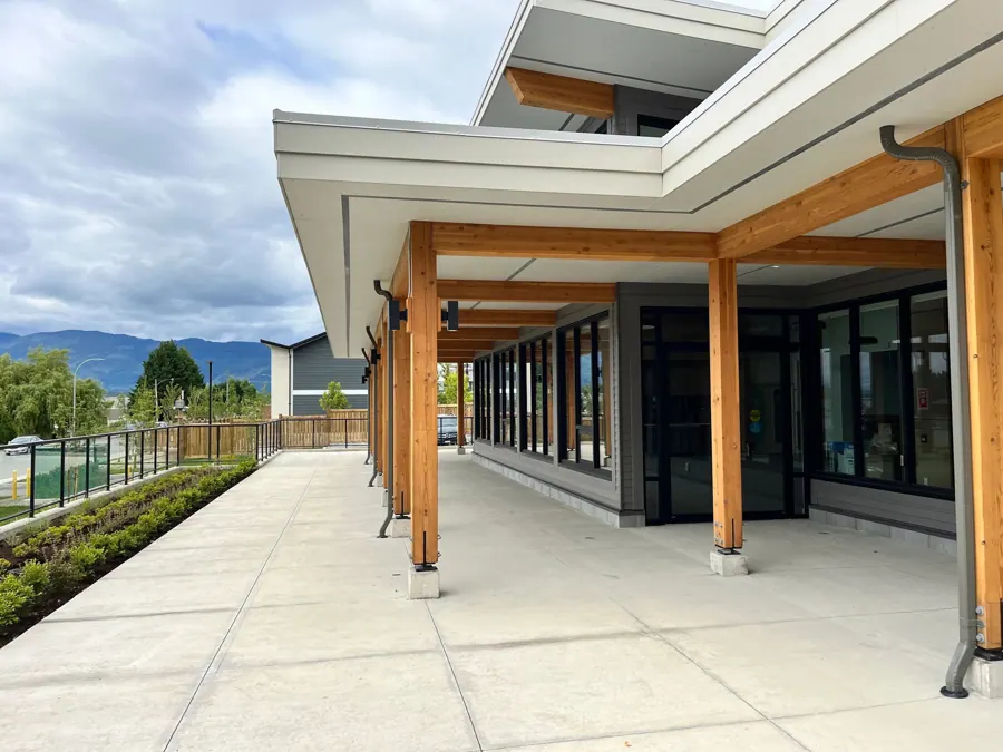 Covered walkway with timber columns, glazing and exterior cladding